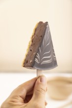 Chocolate and Vanilla Cake pops Marshmallow with hand with cup of coffee on white wooden background