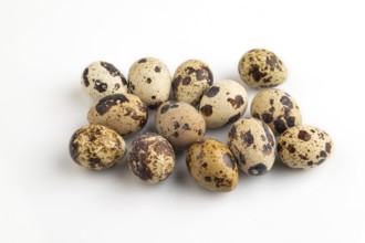 Pile of Raw Quail eggs isolated on white background. side view, close up