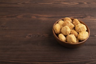Fried crispy Chicken Nuggets on brown wooden background. side view, copy space