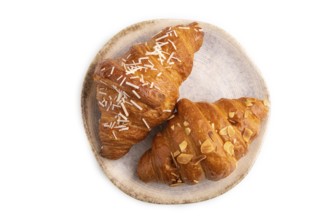 Croissant on blue plate isolated on white background, top view, flat lay, close up
