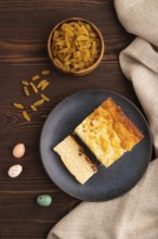 ?ottage cheese ?asserole, Curd cake, with dried apricots and raisins on brown wooden background and
