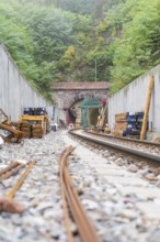 Eisenbahnbaustelle mit sichtbarem Tunnel und gestapeltem Material, Bau der Hermann Hessenahn, Calw,