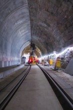 Bauarbeiten im Tunnel mit Schienen, beleuchtet, technische Geräte im Einsatz, Bau der Hermann
