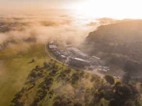 Nebel und Morgensonne schaffen eine atmosphärische Landschaft über Industriegebäuden, Gechingen,