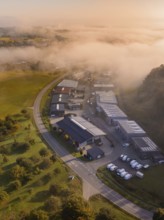 Industriegebäude neben einer Straße in nebliger Morgenstimmung aufgenommen, Gechingen, Heckengäu,