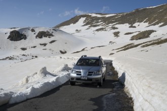 SUV auf enger, von Schnee gesäumter Bergstraße mit klarem Himmel, Aragaz, Aragats, Aragac, Alagyaz,
