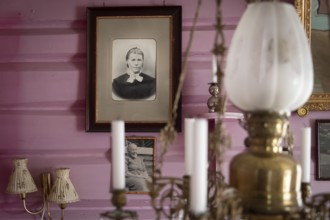 Alte Schwarzweiß-Fotografien an rosa gestrichener Wand, nostalgische Atmosphäre, historischer