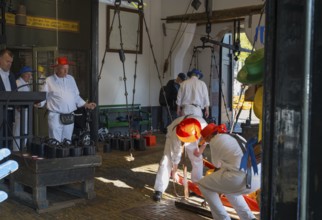 Männer in weiß mit roten Hüten bei der Arbeit auf einem Käsemarkt, ehemalige Stadtwaage, Käse