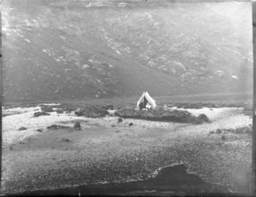 Tent camp on island in river of mountain valley, thought to be Cuillin mountains, Skye, Scotland,