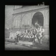 Magic lanterns slide group portrait of children and adults sitting on steps of Hotel Sundal,