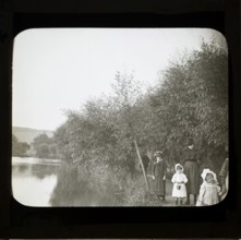 Magic lanterns slide of Edwardian children walking on a footpath next to a river, England, UK c