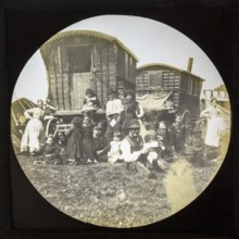 Magic lantern slide portrait of fairground travelling gypsy extended family and caravans, UK circa