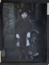 Paget process colourised magic lantern slide portrait of a young girl dressed up in adult clothing,