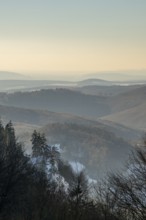 View over the hills and valleys from the mountain with hoarfrost on the branches in winter, Vápec,