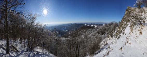 View over the hills and valleys from the mountain with hoarfrost on the branches in winter, Vápec,
