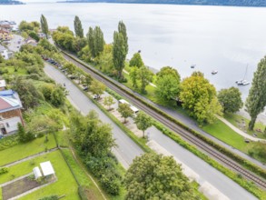 Bird's eye view of a road and railway track flanked by trees and a lake, Lake Constance Germany