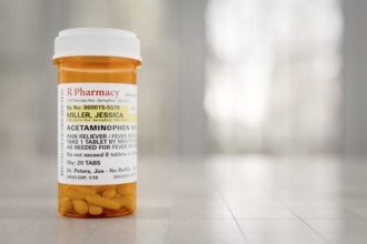 Acetaminophen prescription medicine bottle resting on A bathroom countertop. the label is