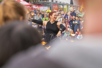 Energetic demonstration with fire wheels in front of an excited audience and curious children,