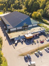 Close-up of an entrance area with car park, surrounded by forest, sunny surroundings, Polarion Ice