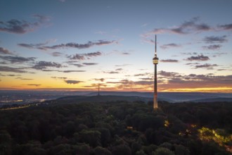 Television tower at dusk over forest and under dramatic sky, Stuttgart-Degerloch,
