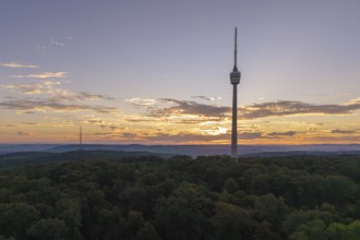 Sunrise behind a television tower in the forest with clouds in the sky, Stuttgart-Degerloch,