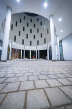Modern architecture with tall columns and night-time lighting, Munich, Germany