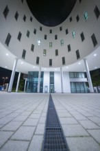 Illuminated entrance area of a modern building with columns, Munich, Germany