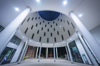 Symmetrical modern building illuminated at night with columns, Munich, Germany