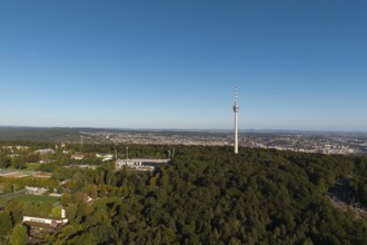 Impressive view over a green forest landscape with a striking television tower and a city in the