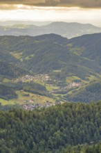 Village nestled in green hills and forests under a cloudy sky, Black Forest, Seebach, Germany