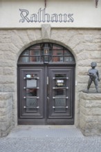 Entrance with cherub to the town hall, front door, inscription, bronze sculpture, nude figure with
