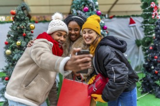 Happy multi ethnic friends enjoying a festive moment while taking a selfie after a day of christmas