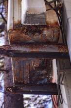 An old and rusty air conditioner hanging on the hotel building, in the sunny outdoor, seaside