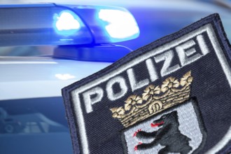 (Photomontage) Symbolic image of a police operation in Berlin: Berlin police emblem in front of