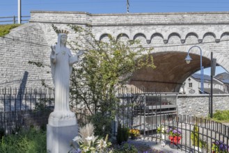 Hawthorn bush and statue of Virgin Mary in front of bridge at Our Lady of Beauraing, Notre-Dame de