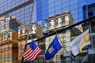 Skyscraper façade with flags and reflection in the glass façade, New York City, USA