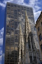 Towers of St Patrick's Cathedral in front of a skyscraper, New York City, USA