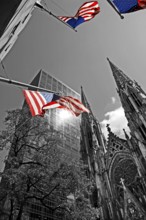 Towers of St Patrick's Cathedral in front of skyscrapers, waving USA flags, New York City, USA