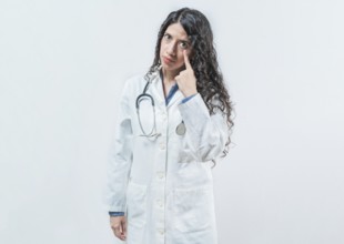 Suspicious female doctor looking you isolated. Suspicious young doctor pointing at eye, isolated