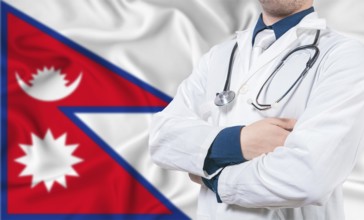 Nepal healthcare concept. Male doctor on Nepal flag. Doctor with crossed arms on Nepal flag