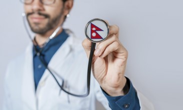 Doctor holding stethoscope with Nepal flag. Nepal health and care concept, Nepal flag on