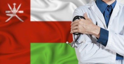 Doctor with stethoscope on Oman flag. Doctor holding stethoscope on Oman flag