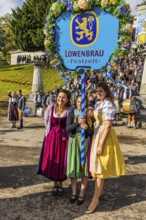 The landlady of the Löwenbräu festival tent in company with flower-decorated table, Wiesnwirte
