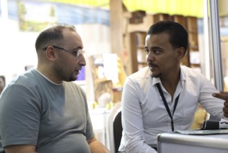 Syrian participants showcase small robots during the Damascus International Fair. The display