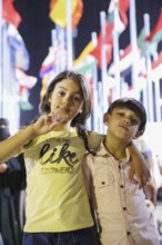 Visitors take souvenir photos at the central square of the Damascus International Fair, with the