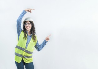 Smiling female builder pointing an advertisement isolated. Beautiful female engineer pointing to