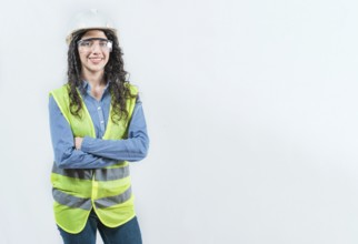 Portrait of smiling female engineer with arms crossed isolated. Young female engineer with helmet
