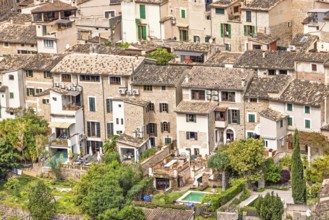 View at old idyllic residential houses with lush green gardens on an old village from an aerial