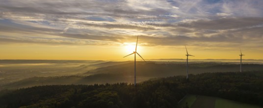 A wide panorama with wind farms at dawn, the sun rises over the landscape, near Schorndorf,