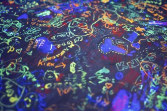 Colourful neon scribbles and graffiti on table top, arcade, Soho, London, England, Great Britain